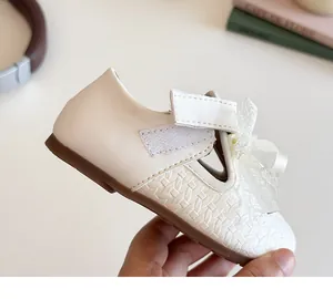 Detail of beige girls mary jane shoes with woven texture and lace bow ornament
