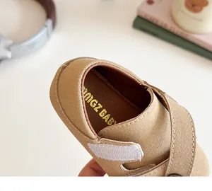 Vista dettagliata delle scarpe da neonato in camoscio kaki con velcro e trama morbida