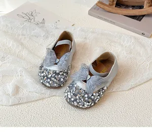 Detail of silver sequined Mary Jane shoes with mesh bow and teardrop rhinestone