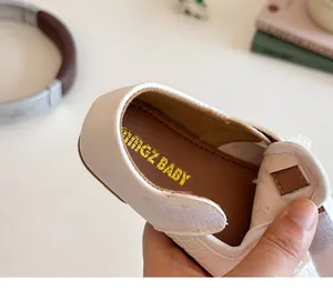 Close-up of baby girl shoes with velcro strap, woven texture, and lace trim details