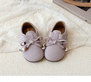 Detailed view of mauve suede girls' princess shoes with bow and bead decorations