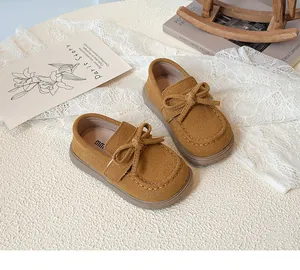Detail view of ginger yellow kid's loafer with bow tie and non-slip rubber sole