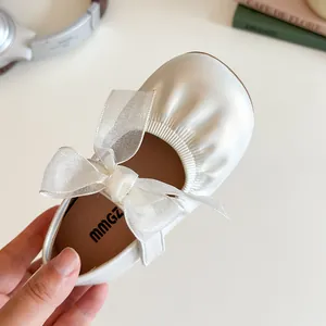 Chic girls cream Mary Jane flats with large mesh bow and elastic strap details