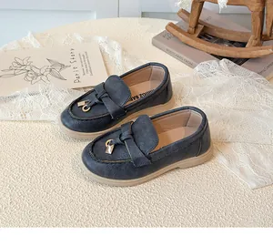 Detail von dunkelblauen Mädchen-Loafers mit Metallschnalle und weichen cremefarbenen Sohlen