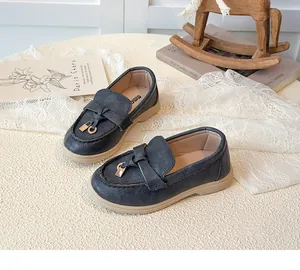 Detailansicht dunkelblauer Mädchen-Loafer mit goldener Schnalle und weicher Gummisohle