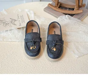 Detailsicht der marineblauen Leder-Loafer für Kinder mit Schnürung und goldenen Schlössern