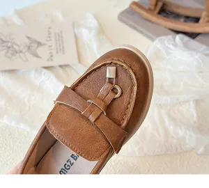 Detailansicht brauner Mädchen-Loafer mit Metallschnalle und weicher Lederstruktur
