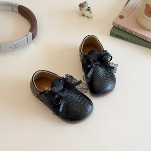 Chic black girls princess shoes with lace bow and woven texture on a minimalist setup