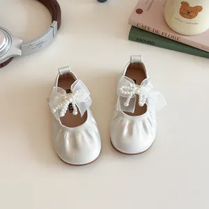 Creamy white girls Mary Jane shoes with tulle bow and pearl accents for spring