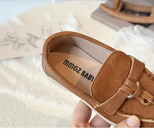 Detail von braunen Mädchen-Loafers aus mattem Leder mit U-Nähten und weicher Sohle