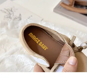 Close-up of khaki suede girls' loafers with velcro strap and decorative beads