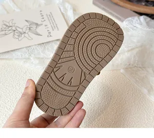 Close-up of brown rubber sole with circular anti-slip texture and size 23 mark