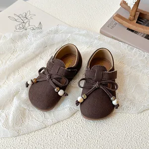 Classic dark brown suede girls' flat shoes with elegant bow and marble bead detail