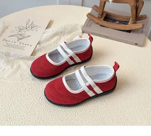 Détail de chaussures Mary Jane rouges en daim pour filles avec brides élastiques blanches et semelle