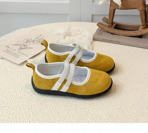Détail de chaussures Mary Jane jaunes pour enfants avec des sangles croisées élastiques
