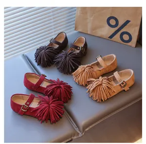 Vue détaillée de trois chaussures Mary Jane pour filles en daim avec pompons