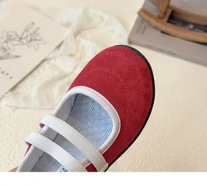 Détail de chaussures Mary Jane en daim rouge avec brides élastiques et coutures