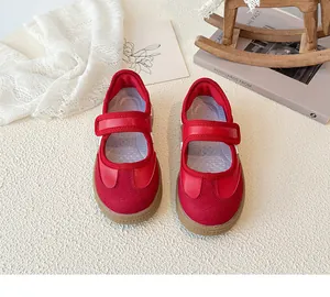 Detail van rode Mary Jane kinderschoenen van leer met handige klittenbandsluiting