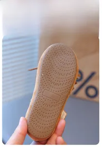 Détail de la chaussure enfant en daim marron montrant la semelle souple antidérapante