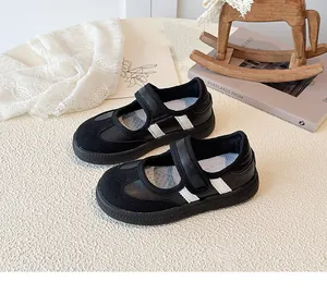Detail van zwarte Mary Jane sneakers voor kinderen met witte strepen en klittenbandsluiting