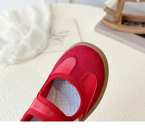 Detailopname van rode leren kinderschoenen met gestreepte voering en rubberen zool