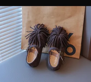 Détail de chaussures Mary Jane pour enfants en daim marron foncé avec franges et boucles