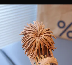 Gros plan de chaussures Mary Jane en daim pour enfant avec détails de franges marrons