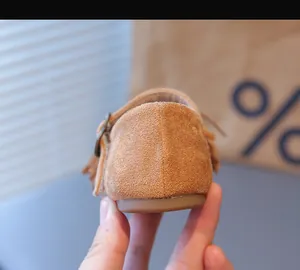 Vue détaillée de chaussures en daim pour enfants avec franges et boucle métallique