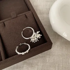 Close-up of vintage silver floral rings with cluster bead design in a jewelry box