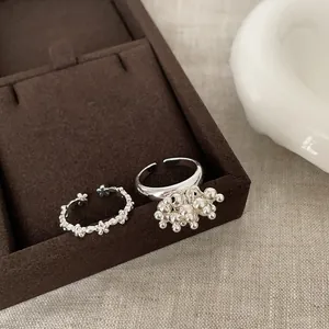 Silver flower ring and beaded tassel open ring set on a jewelry display tray