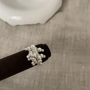Macro shot of silver cluster bead ring on velvet stand showing premium metallic texture