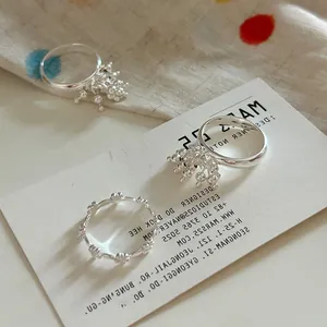 Detailed close-up of three silver-plated rings with tassels and lace textures