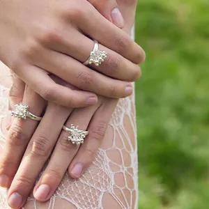 Close-up of stacked silver fireworks flower rings with cluster bead design on model hand