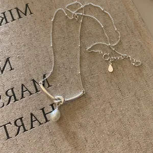 Collana a catena d'argento minimalista con nodo in metallo e pendente con perla bianca