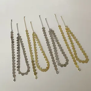 Vista plana de varios collares de metal cepillado oro y plata con corazones y discos