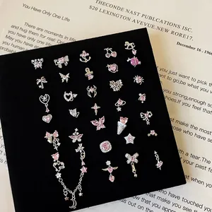 Pink zircon heart and butterfly screw back earrings set displayed on black velvet board