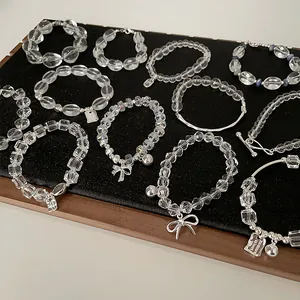 Makroaufnahme von klaren Kristallperlenarmbändern mit silbernen Schmetterlingsanhängern