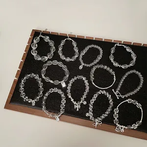 Nahaufnahme der weißen Kristallperlenarmbänder mit silbernen Schmetterlingsanhängern