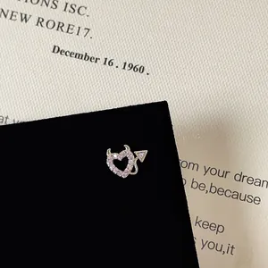 Detailed view of devil heart screw back earring with pink zircons and silver base