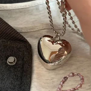 Gros plan détaillé du pendentif coeur 3D métallique avec chaîne à billes
