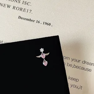 Macro detail of silver winged pink heart stud earring with zircon on a velvet stand