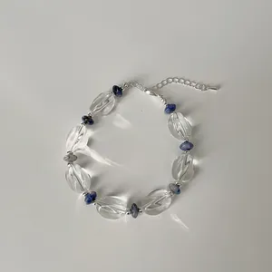 Makroaufnahme von klarem Kristallarmband mit blauen Steinakzenten und Silberverschluss
