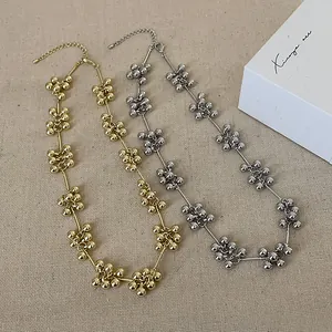 Detail von minimalistischen Perlencluster-Halsketten in Gold und Silber auf Strukturstoff
