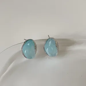 Dettaglio macro degli orecchini a perno camelia blu ghiaccio con bordo in argento