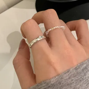 Dettaglio di anelli sovrapponibili con perle retrò e stelle in rilievo argento