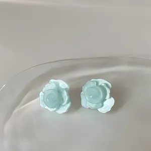 Eleganti orecchini a lobo camelia blu menta con finitura perlata su vassoio bianco