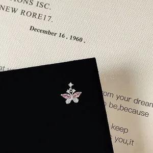 Close-up of a butterfly screw back earring with pink zircon on black velvet display