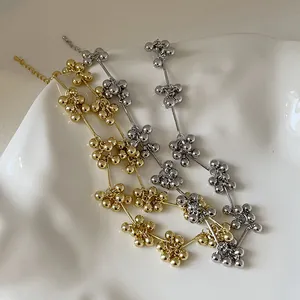 Minimalistische Perlenketten aus Metall in Gold und Silber auf einem weißen Keramikteller