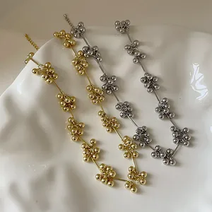 Makro-Detail von gold- und silbernen Perlenketten auf einem strukturierten Keramiktablett
