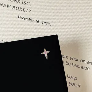 Close-up of a pink zircon star stud earring on a vintage textured paper background